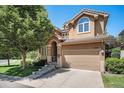 Attractive home with manicured front yard featuring an attached two-car garage, mature tree and covered front entrance at 12051 E Lake Cir, Greenwood Village, CO 80111