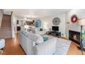 Inviting living room with fireplace, hardwood floors and open floor plan to kitchen at 5252 W 68Th Ave, Arvada, CO 80003