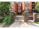 Exterior of a brick building with landscaped entrance, pathway, and wrought iron fence at 1631 N Emerson St # 207, Denver, CO 80218