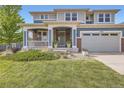 Inviting two-story home with a covered porch, two-car garage, and well-maintained landscaping for curb appeal at 7485 S Jackson Gap Way, Aurora, CO 80016