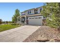 Two-story home featuring a two-car garage, a landscaped yard, and a covered front porch at 7485 S Jackson Gap Way, Aurora, CO 80016