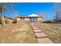 View of the brick and siding of this single-story house with a well-maintained front yard at 8520 Franklin Dr, Denver, CO 80229