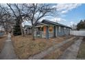 Charming blue home featuring a covered front porch and well-maintained landscaping at 1560 Clinton St, Aurora, CO 80010