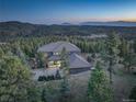 Scenic aerial view of a gorgeous home surrounded by mature trees with mountain range backdrop at 28154 Belle Mont Trl, Conifer, CO 80433