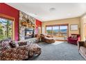 Charming living room features a stone fireplace, plush seating, and expansive windows with scenic views at 278 Snowshoe Cir, Breckenridge, CO 80424