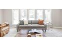 Bright living room with a comfortable gray sofa, decorative pillows, a stylish coffee table, and a large window at 4821 W 102Nd Ave, Westminster, CO 80031