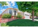 A well-manicured lawn and landscaping accentuate this single Gathering home with an attached garage at 5740 S Tempe Ct, Aurora, CO 80015