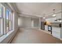 Open living room and kitchen with large windows and neutral carpeting at 3233 Vallejo St # 3B, Denver, CO 80211