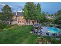 Expansive backyard features a large pool, covered seating area, and well-maintained lawn at 8439 Greenwood Dr, Niwot, CO 80503