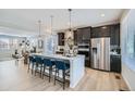 Modern kitchen featuring a large center island with barstool seating and stainless steel appliances at 1751 Peak Loop, Broomfield, CO 80023