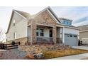 Stylish home featuring stone accents, a covered porch, and a well-maintained front yard at 22773 E Narrowleaf Cir, Aurora, CO 80016