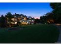 Expansive backyard featuring lush lawn, covered patio, and mature trees at 8717 Ridgepoint Dr, Castle Pines, CO 80108