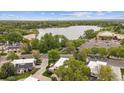Aerial view showcasing the property's location near a lake and surrounding greenery with city skyline at 1799 S Lee St # B, Lakewood, CO 80232