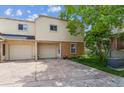 Exterior view of the townhouse with a garage, brick accents, and a well-manicured lawn at 1799 S Lee St # B, Lakewood, CO 80232