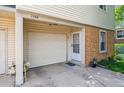 Attached garage with secure entry door, flower bed, and well-maintained exterior at 1799 S Lee St # B, Lakewood, CO 80232