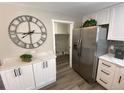 Modern kitchen featuring stainless steel refrigerator, white cabinetry, and an adjacent pantry at 1263 N Willow St, Denver, CO 80220