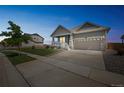 Exterior view of a two-story single-Gathering home at twilight featuring a well-kept lawn and a two-car garage at 17788 Olive St, Broomfield, CO 80023