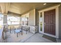 Inviting front porch with chairs, a table, and stylish stone accents, offering a cozy outdoor seating area at 17788 Olive St, Broomfield, CO 80023