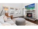 Cozy living room featuring a stone fireplace, hardwood floors, and plenty of natural light at 22463 E Mosey Cir, Parker, CO 80138