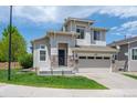 Inviting two-story home featuring stone accents, manicured lawn, and two-car garage at 10685 Cherrybrook Cir, Highlands Ranch, CO 80126