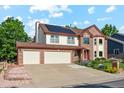 Attractive two-story home with brick and siding, featuring a three-car garage and lush green lawn at 12752 W Dakota Ave, Lakewood, CO 80228