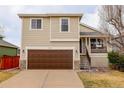 Charming two-story home with a brown garage door, stone accents, and a cozy front porch at 9879 Saybrook St, Highlands Ranch, CO 80126