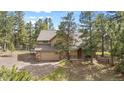 Charming two-story home with a stone facade and attached two-car garage surrounded by mature trees at 4992 White House Trl, Evergreen, CO 80439