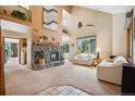 Inviting living room features soaring ceilings, a stone fireplace, and large windows with scenic views at 4992 White House Trl, Evergreen, CO 80439