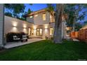 Beautiful backyard with a stone patio, lush greenery, and elegant outdoor lighting at 2377 S Humboldt St, Denver, CO 80210
