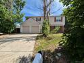 Two-story home featuring a two-car garage, red shutters, a driveway, and mature trees at 16835 E Harvard Pl, Aurora, CO 80013