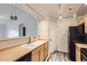 Efficient kitchen area with ample cabinets, track lighting, and a view to the connected living area at 5255 Memphis St # 224, Denver, CO 80239