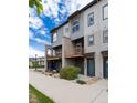 Modern townhome exterior featuring a balcony, covered seating, landscaped front yard, and inviting entryway at 10154 Belvedere Loop, Lone Tree, CO 80124