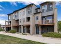 Contemporary townhomes with two-tone gray exterior, individual balconies, and landscaped front yards at 10154 Belvedere Loop, Lone Tree, CO 80124