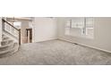 Spacious carpeted living room with staircase and natural light at 3523 Brushwood Dr, Castle Rock, CO 80109