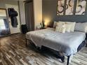 Inviting bedroom featuring wood-look flooring, calming gray walls, and three decorative pieces above the bed at 14344 E Hawaii Cir # B, Aurora, CO 80012