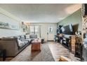 Bright living room featuring a plush sofa, accent wall, and a large window at 14344 E Hawaii Cir # B, Aurora, CO 80012