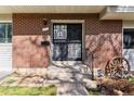 Close up of the townhome's brick front door with security screen and decorative wagon wheel at 625 S Xenon Ct, Lakewood, CO 80228