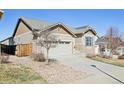 View of the home featuring a two-car garage, stone accents, and low maintenance yard at 24437 E Powers Ave, Aurora, CO 80016
