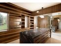 Bright walk-in closet boasts custom wood shelving, drawers, and a spacious center island at 4935 E Preserve Ln, Greenwood Village, CO 80121
