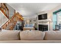 Cozy living room featuring a fireplace, staircase, and comfortable seating at 17467 E Rice Cir # C, Aurora, CO 80015