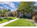 Beautiful home showcasing a well-maintained lawn, mature trees, and an inviting covered porch at 4645 Quitman St, Denver, CO 80212