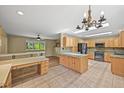 Spacious kitchen featuring tile floors, wooden cabinets, and a center island at 1335 S Kio St, Watkins, CO 80137