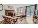 Comfortable living room with fireplace, hardwood floors, and access to outdoor balcony at 7893 Allison Way # 101, Arvada, CO 80005