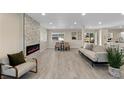 Open-concept living area featuring modern fireplace and dining area at 2230 Jamaica, Aurora, CO 80010