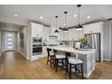 Modern kitchen featuring white cabinets, stainless steel appliances, and a center island with seating at 8360 Snake River St, Littleton, CO 80125