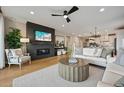 Bright living room featuring a fireplace, modern ceiling fan, and wood flooring at 8360 Snake River St, Littleton, CO 80125