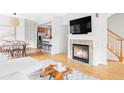 Spacious living room with hardwood floors, fireplace, and open access to dining and kitchen at 9124 E 29Th Pl, Denver, CO 80238