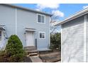 Inviting entrance of the home featuring light blue siding, a white door, and a small garden at 2862 W Warren Ave, Denver, CO 80219
