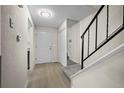 Bright foyer with modern flooring, staircase and coat closet at 2862 W Warren Ave, Denver, CO 80219