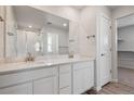 Bathroom featuring a double sink vanity with quartz countertop and a glass enclosed shower at 3352 N Highlands Creek Pkwy, Aurora, CO 80019